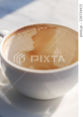 Coffee cup with remnants of beverage on a sunny morning 126734415