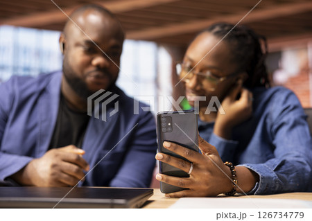 Black couple coworkers joining their colleagues on a video call connection, enjoying the benefits of a remote job through online communication from their home. Virtual briefing meeting. Black couple coworkers joining their colleagues on a video call connection, enjoying the benefits of a remote job through online communication from their home. Virtual briefing meeting. 126734779