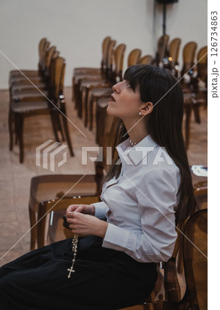 Woman Immersed In The Prayer At The Church With A Rosary  126734863