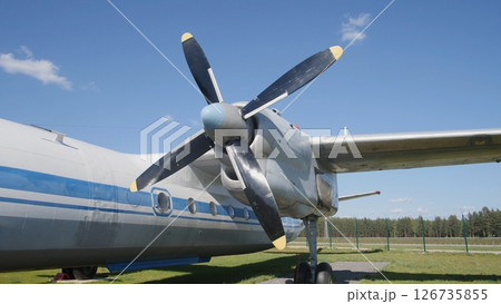 Detailed View of a Propeller Aircraft Parked on a Green Field Under a Clear Blue Sky During Daytime at an Airstrip in Summer Detailed View of a Propeller Aircraft Parked on a Green Field Under a Clear Blue Sky During Daytime at an Airstrip in Summer 126735855
