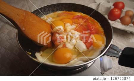 Cooking Delicious Scrambled Eggs With Fresh Tomatoes on a Stovetop in a Cozy Kitchen During Morning Hours Cooking Delicious Scrambled Eggs With Fresh Tomatoes on a Stovetop in a Cozy Kitchen During Morning Hours 126735874