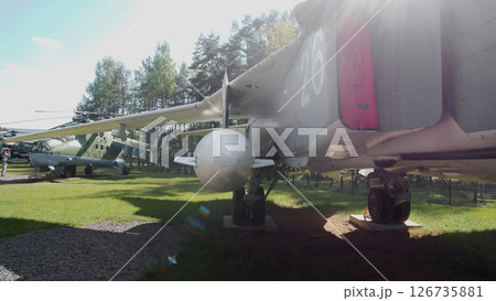 Soviet Military Aircraft Displayed in a Green Field Surrounded by Trees During a Sunny Day in a Historical Aviation Park 126735881