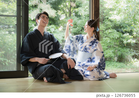 緑が美しい縁側でくつろぐ浴衣の男性と美しい女性 旅行や旅館などの風鈴を見る男女 湯上り温泉のイメージ 緑が美しい縁側でくつろぐ浴衣の男性と美しい女性 旅行や旅館などの風鈴を見る男女 湯上り温泉のイメージ 126736055