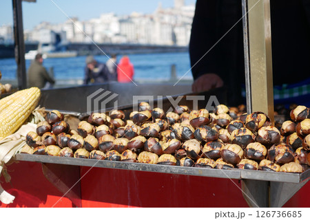 Roasted chestnuts at a waterfront market in autumn Roasted chestnuts at a waterfront market in autumn 126736685