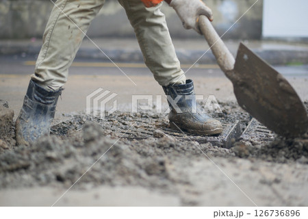 Construction worker digs in urban area during daylight hours Construction worker digs in urban area during daylight hours 126736896