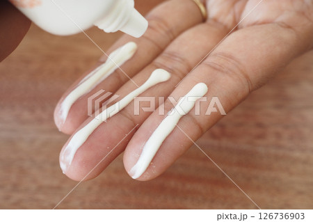 Applying sunscreen cream to fingers for skincare routine Applying sunscreen cream to fingers for skincare routine 126736903