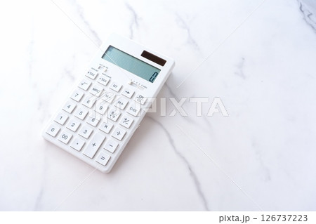 白いテーブルの上に置かれた、白い電卓 126737223