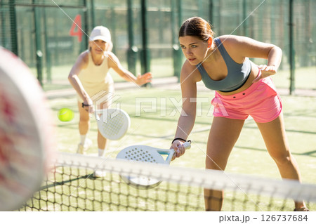 Young woman playing Padel Tennis in open-air tennis court 126737684