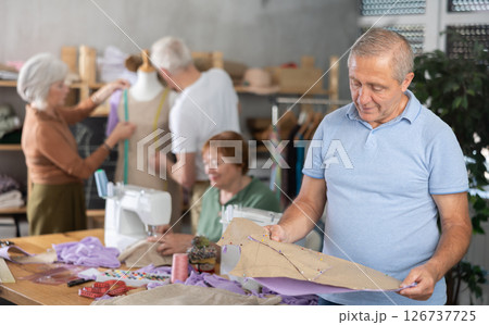 Elderly man with pattern at sewing master class 126737725