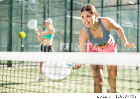 Young woman playing Padel Tennis in open-air tennis court Young woman playing Padel Tennis in open-air tennis court 126737738