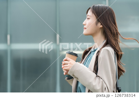 コーヒーを持つオフィスカジュアルのスーツ姿の若いアジア人ビジネスウーマン 126738314