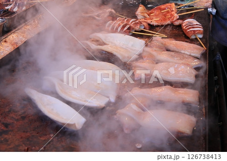 大きなイカ焼きの屋台　湯気を上げて焼かれるイカ 126738413