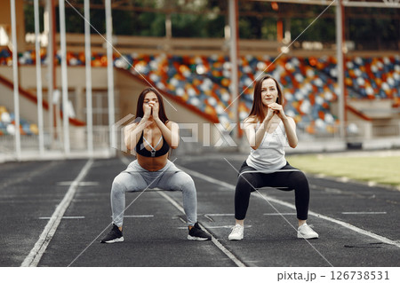 Beautiful girls at the stadium. Sports girls in a sportswear. People use a eraser. 126738531