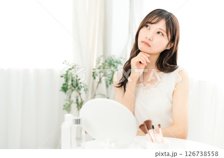 鏡を見ながら肌トラブルで悩む若いアジア人女性(スキンケア) 鏡を見ながら肌トラブルで悩む若いアジア人女性(スキンケア) 126738558