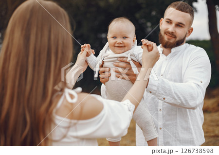 Parents with daughter. Family in a field. Newborn girl. Woman in a white dress. Parents with daughter. Family in a field. Newborn girl. Woman in a white dress. 126738598