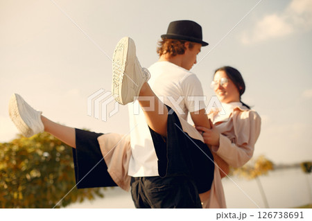 Couple by the water. Guy in a black hat. Pair on a sunset background. People dances. Couple by the water. Guy in a black hat. Pair on a sunset background. People dances. 126738691