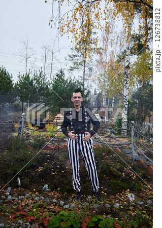 A Stylish Individual Dressed in Colorful Striped Pants Surrounded by Beautiful Autumn Foliage A Stylish Individual Dressed in Colorful Striped Pants Surrounded by Beautiful Autumn Foliage 126738812