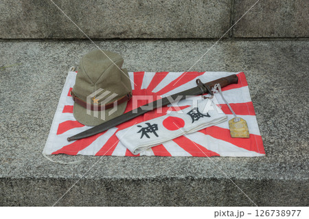 【日本】東京都千代田区の靖国神社に置かれた第二次大戦当時の旭日旗と軍帽、軍刀、日の丸と神風の鉢巻 126738977