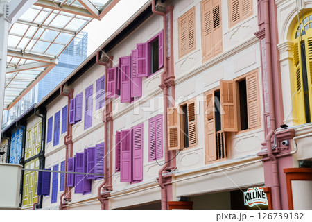Singapore, Singapore - 4 April 2025: Colorful colonial-style shophouse windows with open shutters in the vibrant Little India district under a glass canopy. 126739182