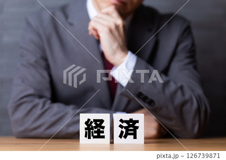 経済のブロックとスーツを着て悩むミドル男性ビジネスマン 126739871
