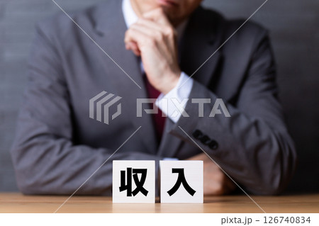 収入のブロックとスーツを着て悩むミドル男性ビジネスマン 126740834
