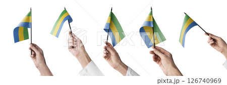The Gabon flag in hand in different angles on a white background 126740969