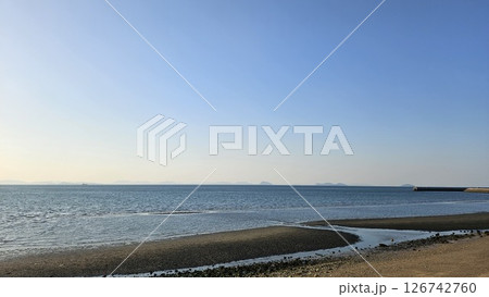 夕日で淡く黄金色に染まった空と干潮時の海 夕日で淡く黄金色に染まった空と干潮時の海 126742760