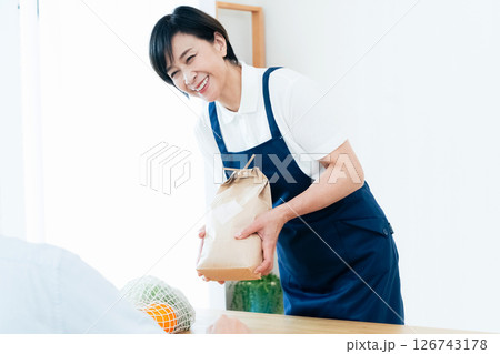 食材をテーブルに並べるホームヘルパーの女性 126743178