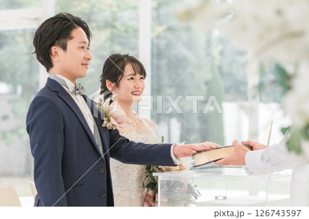 チャペル,教会で神父と宣誓・誓う新郎新婦(結婚式) チャペル,教会で神父と宣誓・誓う新郎新婦(結婚式) 126743597