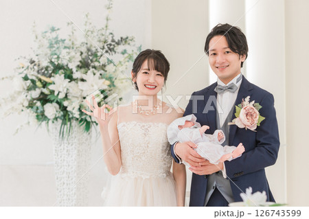 結婚式場で赤ちゃんと一緒に結婚式をあげる新郎新婦(授かり婚・おめでた婚・パパママ婚) 結婚式場で赤ちゃんと一緒に結婚式をあげる新郎新婦(授かり婚・おめでた婚・パパママ婚) 126743599