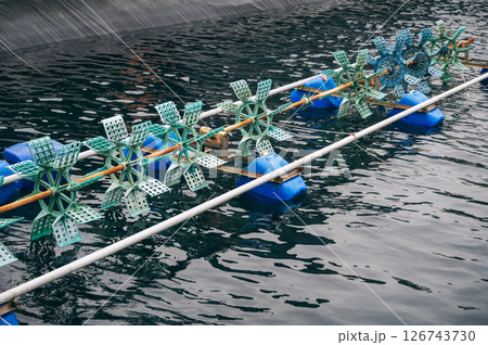 Aerator blades in a pond on fish farm. Fish farming Aerator blades in a pond on fish farm. Fish farming 126743730