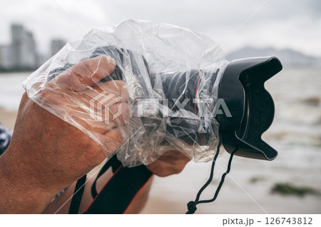 professional camera in a waterproof case that protects against rain and splashes in nature on rainy day professional camera in a waterproof case that protects against rain and splashes in nature on rainy day 126743812