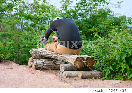 登山の休憩中にストレッチしている男性 登山の休憩中にストレッチしている男性 126744374
