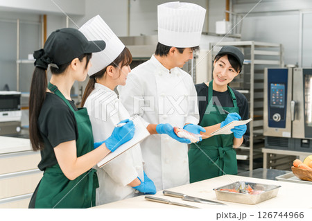 調理師のセミナー・勉強会で教えるシェフ,料理人と受講者の女性 126744966