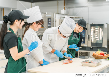 調理師のセミナー・勉強会で教えるシェフ,料理人と受講者の女性 126744967
