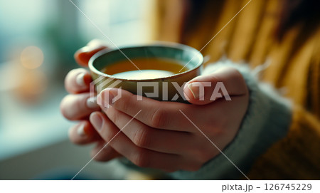 メンタルヘルスケアを意識した温かいお茶を手に取るリラックスシーン メンタルヘルスケアを意識した温かいお茶を手に取るリラックスシーン 126745229