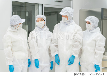 防護服,クリーンウェアを着る製造工場で働くスタッフの男女 126745421