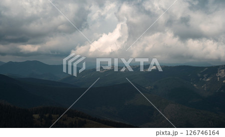 A sweeping view of rolling mountain ranges under a cloud-filled sky. A sweeping view of rolling mountain ranges under a cloud-filled sky. 126746164