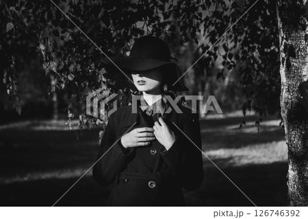 A Mysterious Figure Dressed in Black and White Amidst a Beautiful Outdoor Environment 126746392