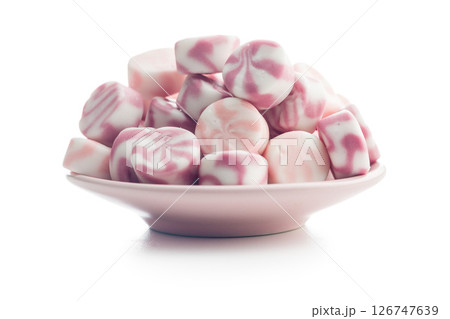 Colorful striped candies on plate isolated on white background. 126747639