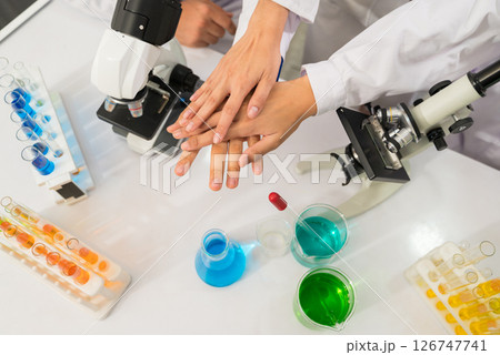Group of scientists team join hands with laboratory microscopes equipment and chemical glassware in laboratory Group of scientists team join hands with laboratory microscopes equipment and chemical glassware in laboratory 126747741