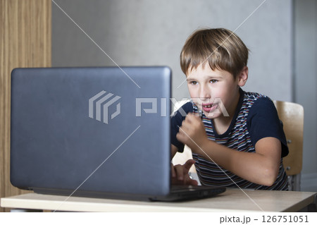 Schoolboy during online lesson at home, social distance during quarantine, self-isolation, online education concept. Elementary age boy at laptop at home. Schoolboy during online lesson at home, social distance during quarantine, self-isolation, online education concept. Elementary age boy at laptop at home. 126751051
