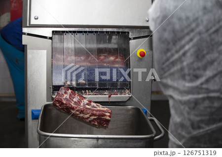 Industrial machine in a meat factory for cutting pieces of meat. 126751319