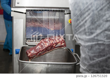 Industrial machine in a meat factory for cutting pieces of meat. Industrial machine in a meat factory for cutting pieces of meat. 126751320