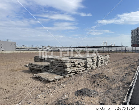 Construction Site Featuring Stacked Concrete Slabs Surrounded by an Urban Environment 126751554