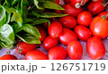 Fresh, juicy Tomatoes and aromatic Basil elegantly displayed on Newspaper for all to enjoy 126751719