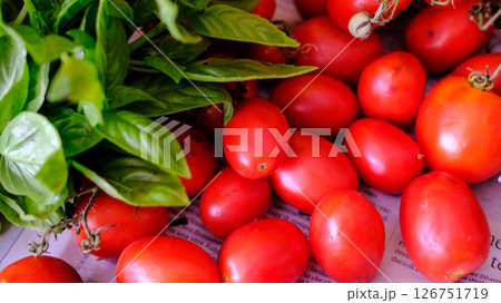 Fresh, juicy Tomatoes and aromatic Basil elegantly displayed on Newspaper for all to enjoy 126751719