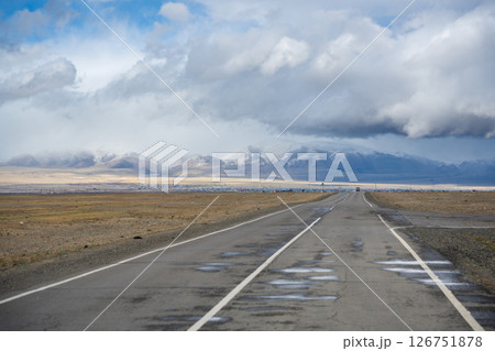 Road from the Mongolian border to Kosh-Agach Altai Russia in a remote mountain landscape. Scenic route through steppe and rugged terrain connecting two regions. 126751878