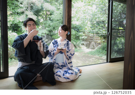 縁側で和菓子を食べるカップル 126752035