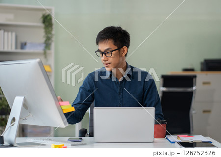 Businessman using laptop computer in office. Happy man, entrepreneur, small business owner working online. 126752326